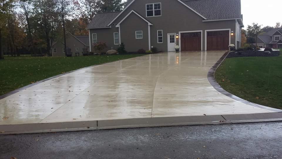 A large house with a concrete driveway in front of it
