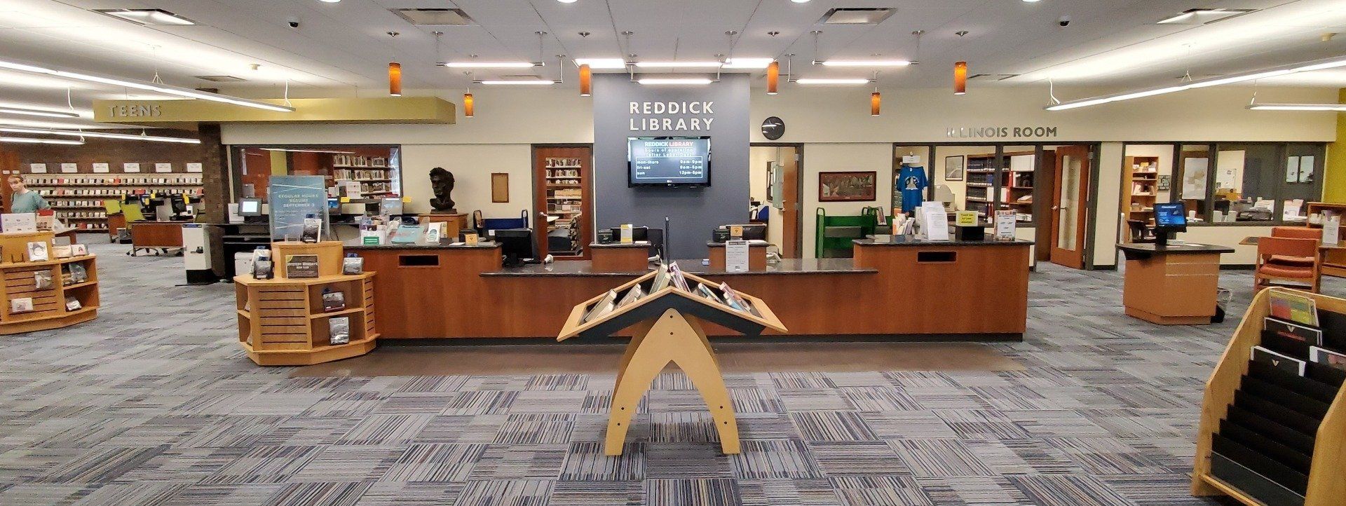 A library with a counter in the middle of the room.