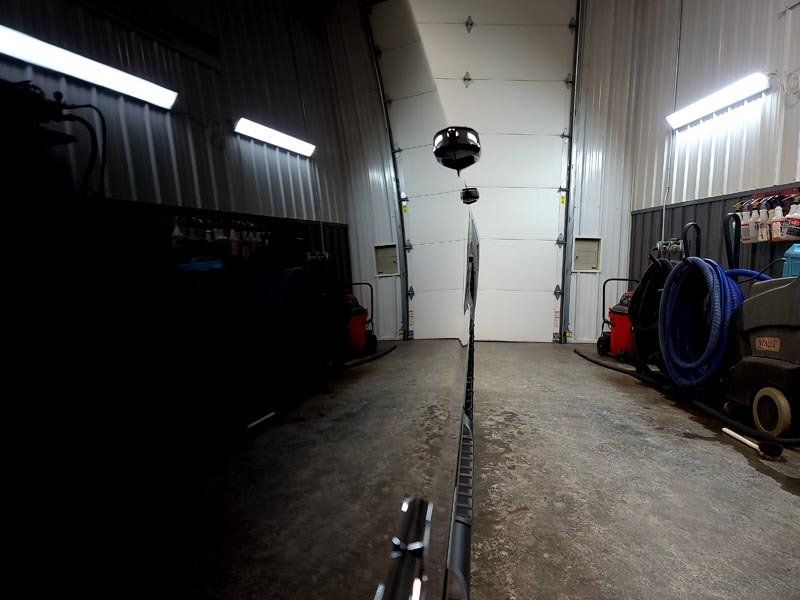 A dark garage with a white garage door