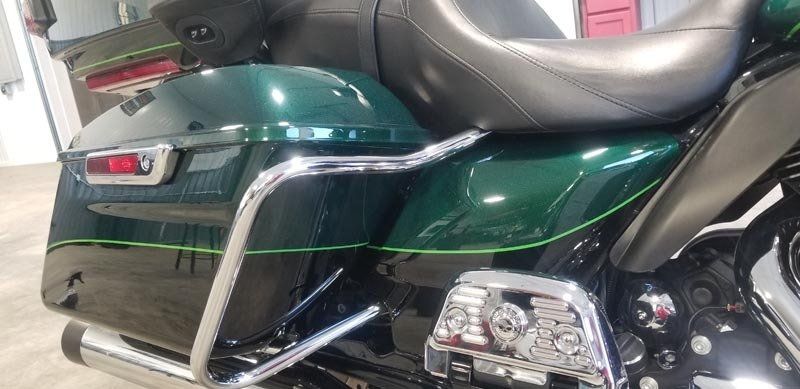 A green harley davidson motorcycle is parked in a garage.