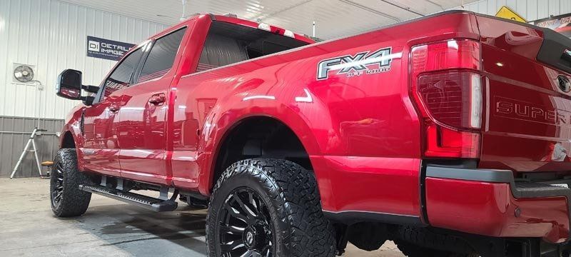 A red pickup truck is parked in a garage.