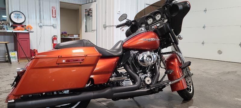 A red harley davidson motorcycle is parked in a garage.