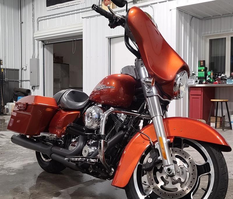 A harley davidson motorcycle is parked in front of a garage