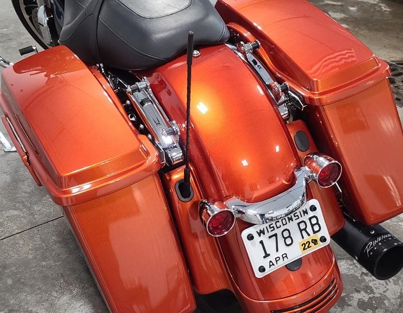 An orange harley davidson motorcycle with a wisconsin license plate