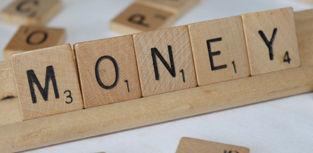A scrabble board with the word money written on it