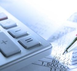 A calculator is sitting on top of a piece of paper with numbers on it