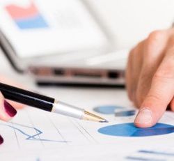 A person is pointing at a graph with a pen.