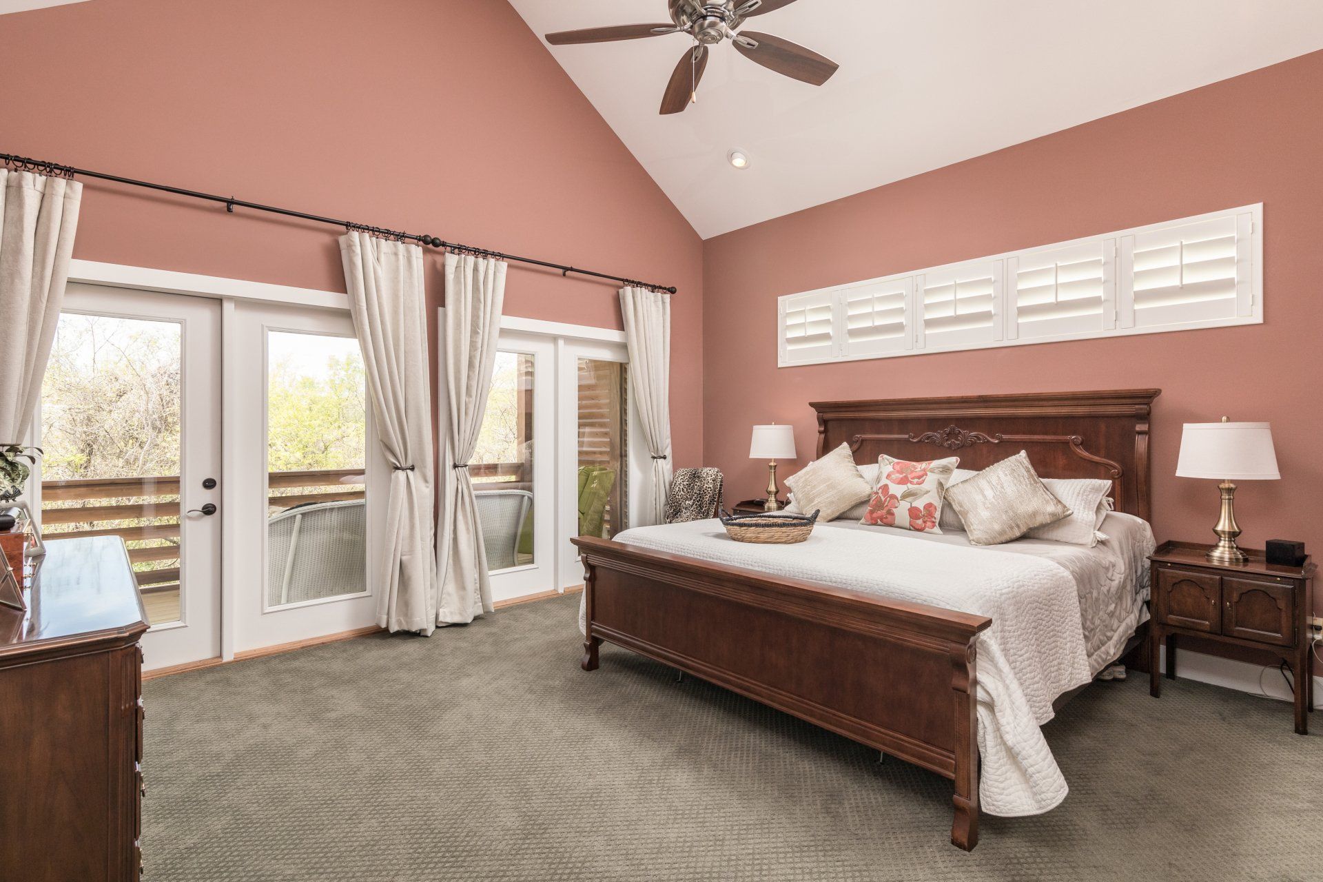 A bedroom with a king size bed and a ceiling fan.