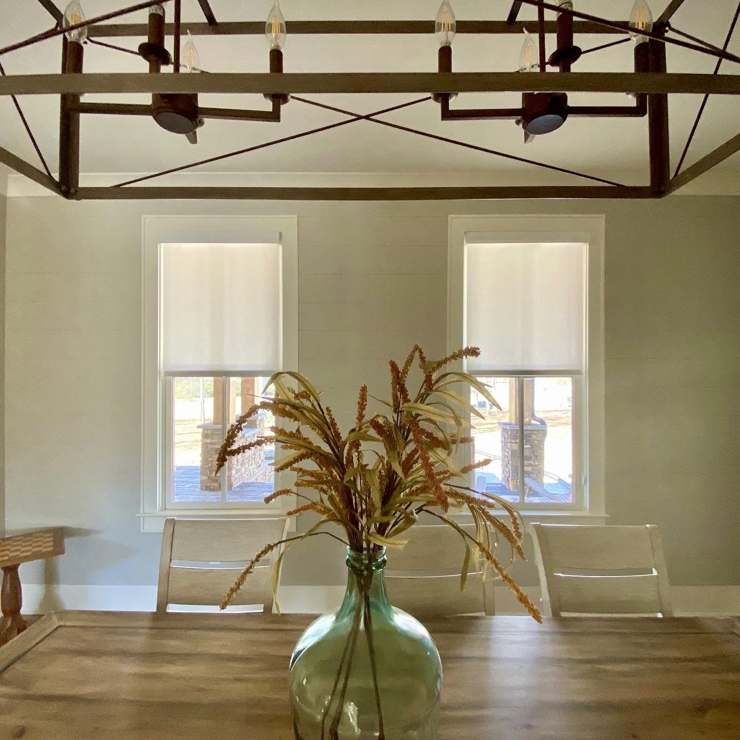 A dining room table with a vase of flowers on it