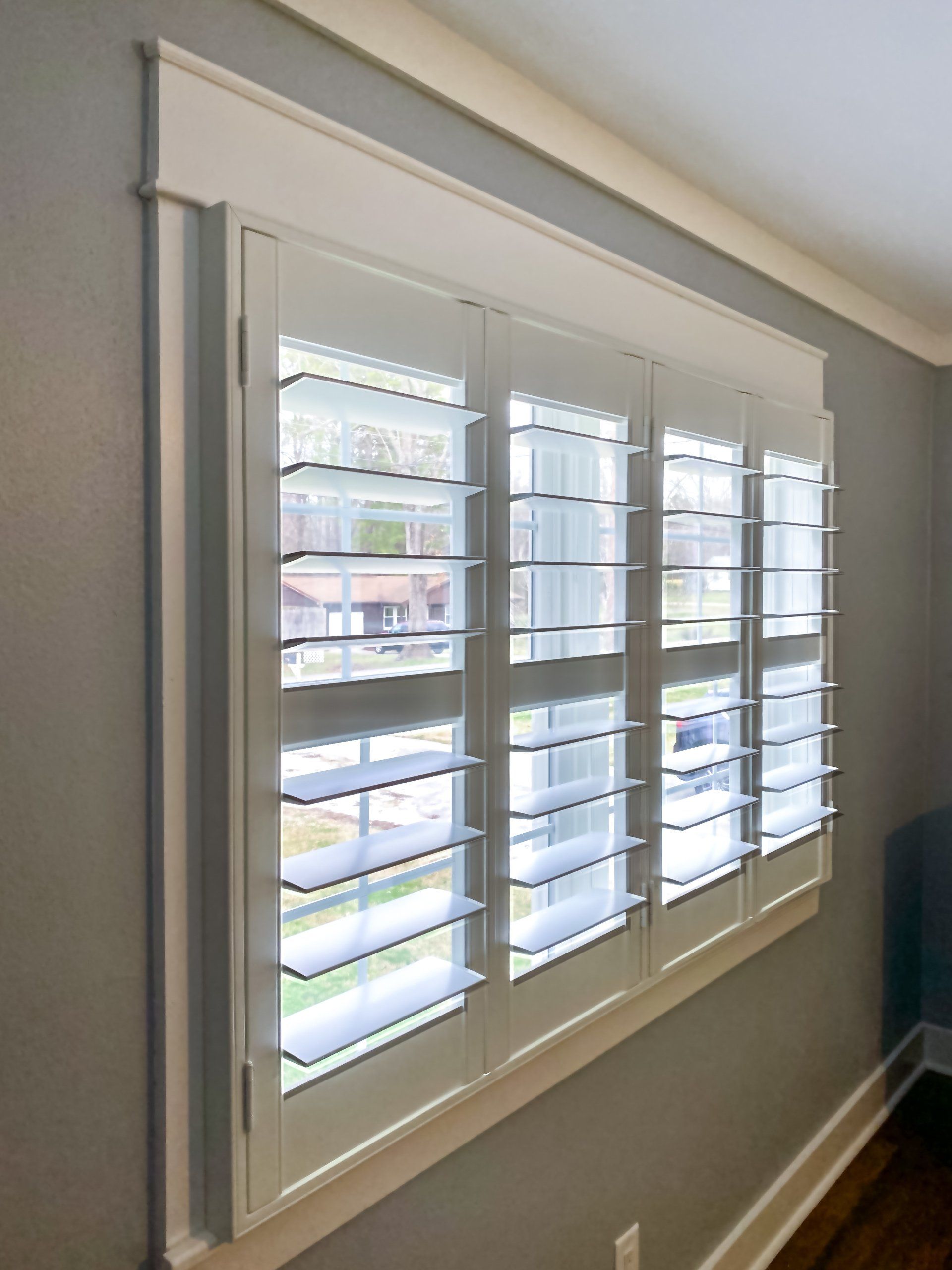 A room with a window with shutters on it