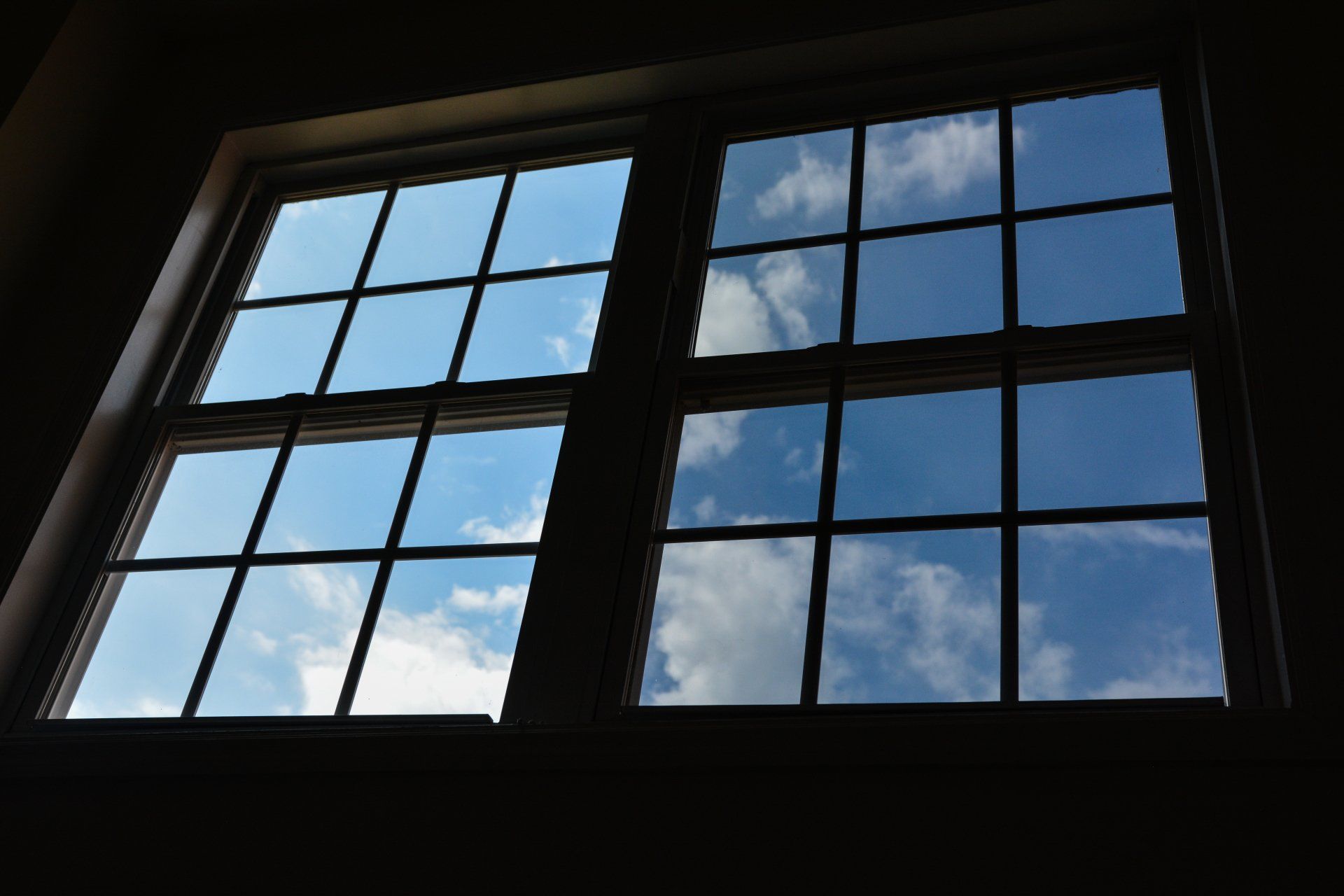 Looking out a window at a blue sky with clouds