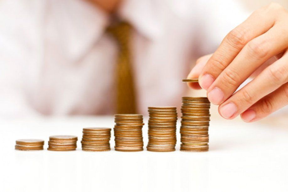 man sitting at desk stacking coins