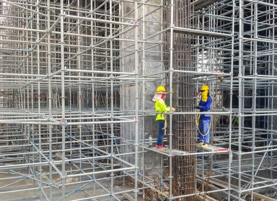 oparai che lavorano in un ponteggio in cantiere
