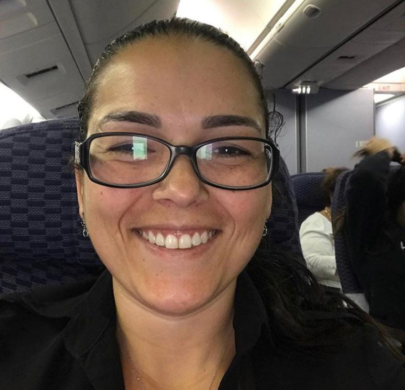 Uma mulher de óculos está sorrindo em um avião