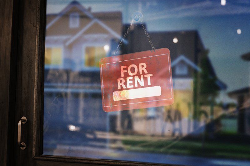 A for rent sign hanging in a shop window