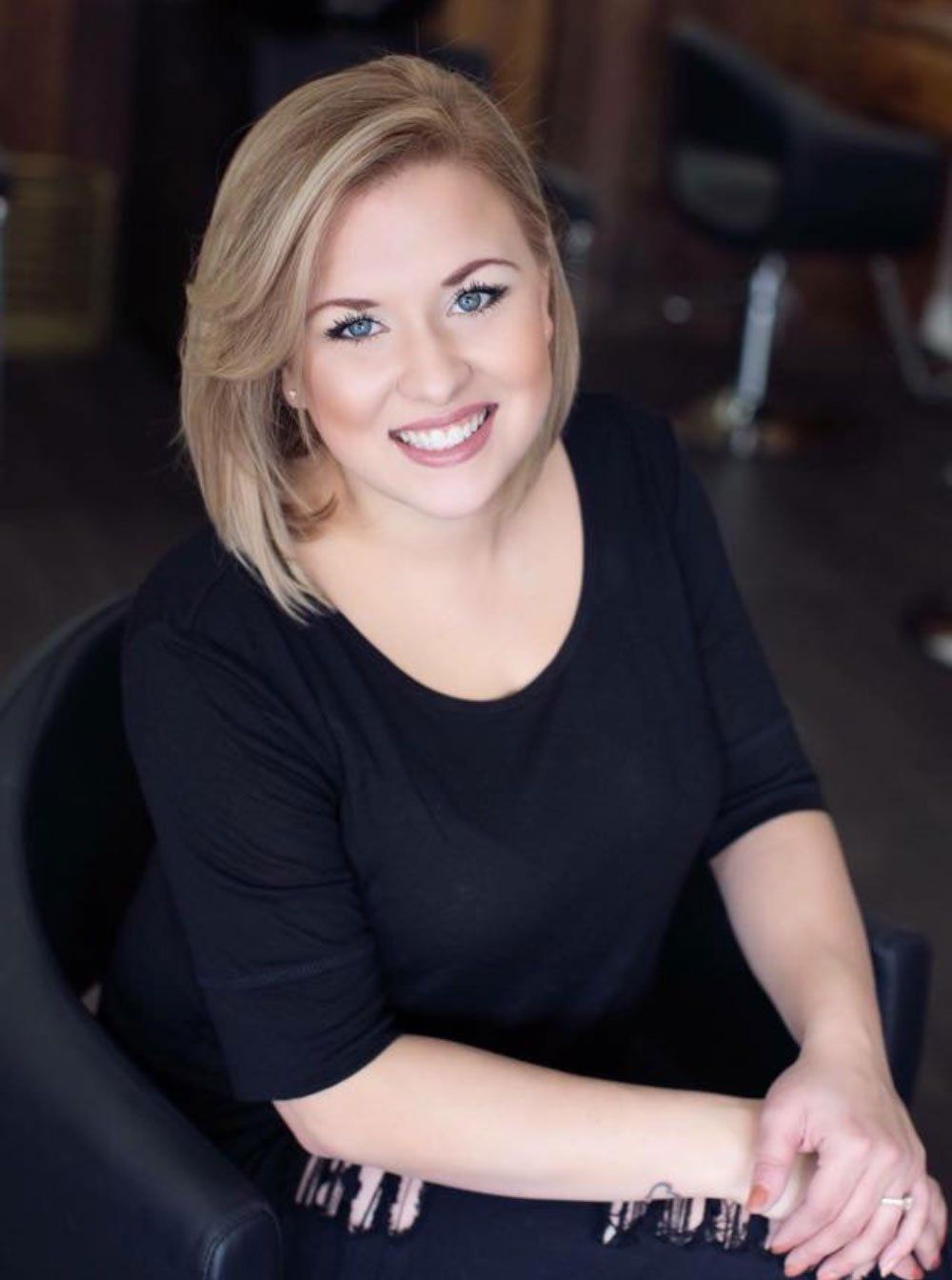 a woman in a black shirt is smiling for the camera