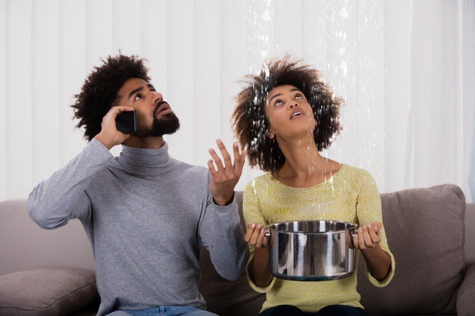 Kitchen Remodeling — Man and Woman Looking at Ceiling Leaking in Irving, TX
