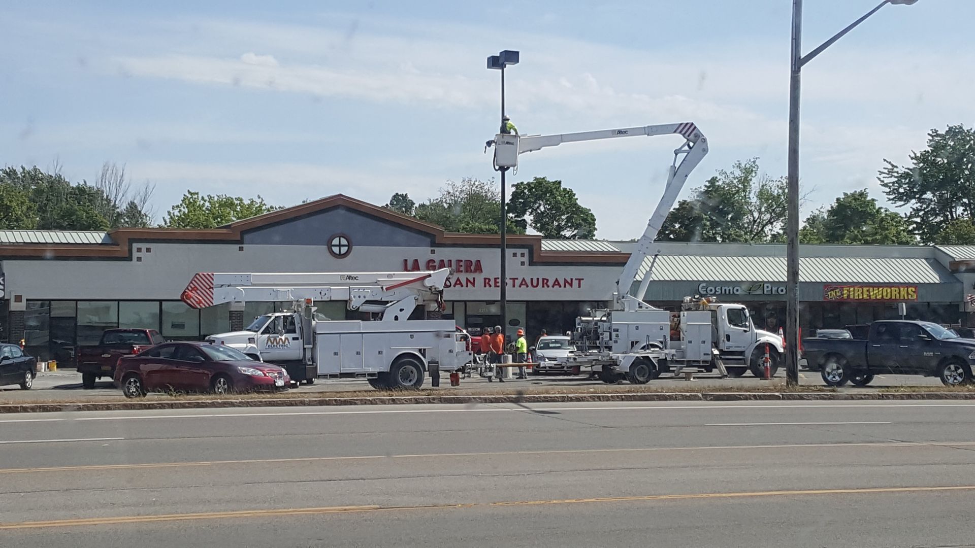 Bucket truck working on a sign in front of a restaurant called