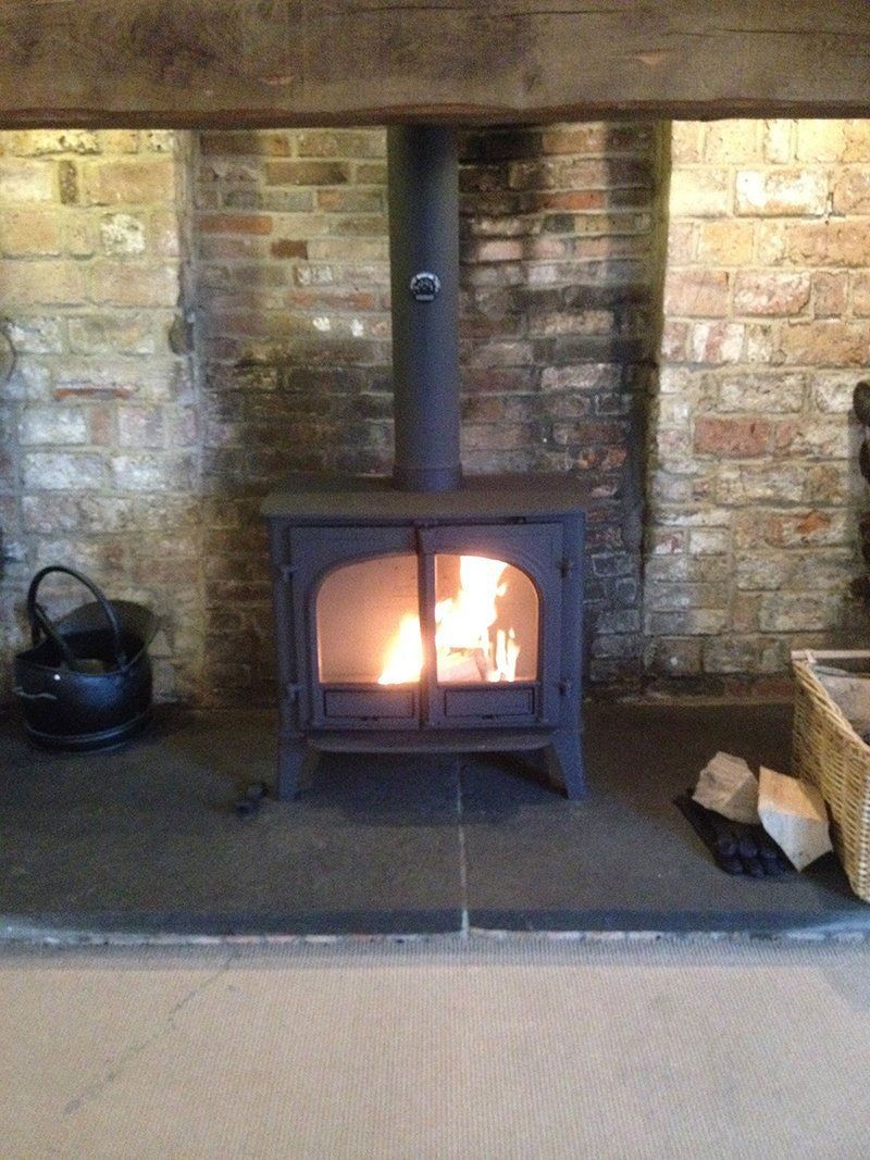 Stove fitted in a stone fireplace