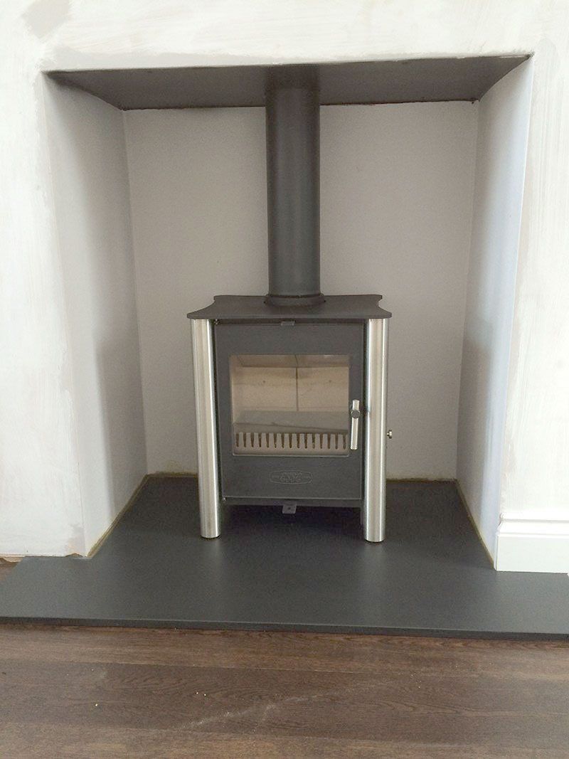 Stove fitted in a white fireplace