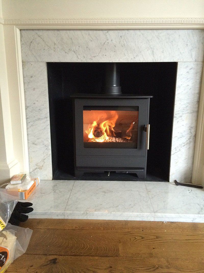 Black stove fitted in a marble fireplace