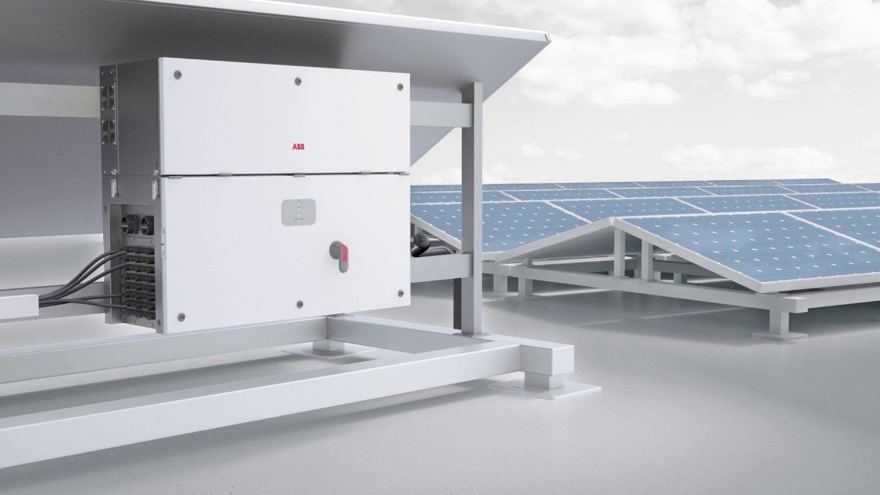 Zonnepanelen naast een witte elektrische omvormer op een plat dak.