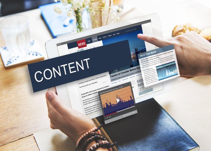 A person is holding a tablet with the word content on it.