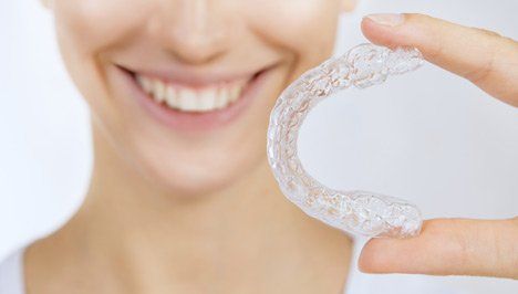 woman holding invisalign
