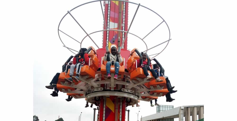 A group of people are riding a ferris wheel at an amusement park.