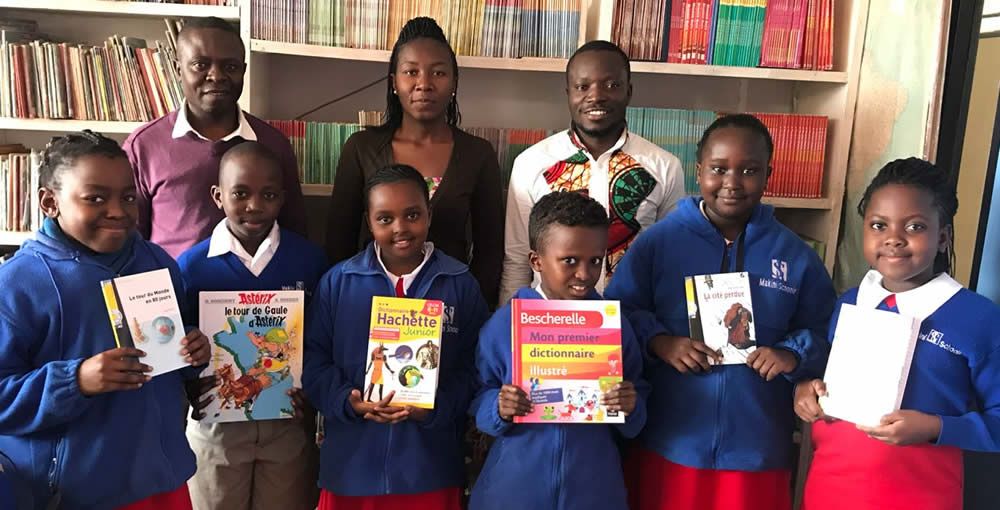 A group of children are holding books in a library.