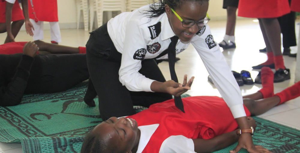 A woman is helping a child who is laying on the floor.