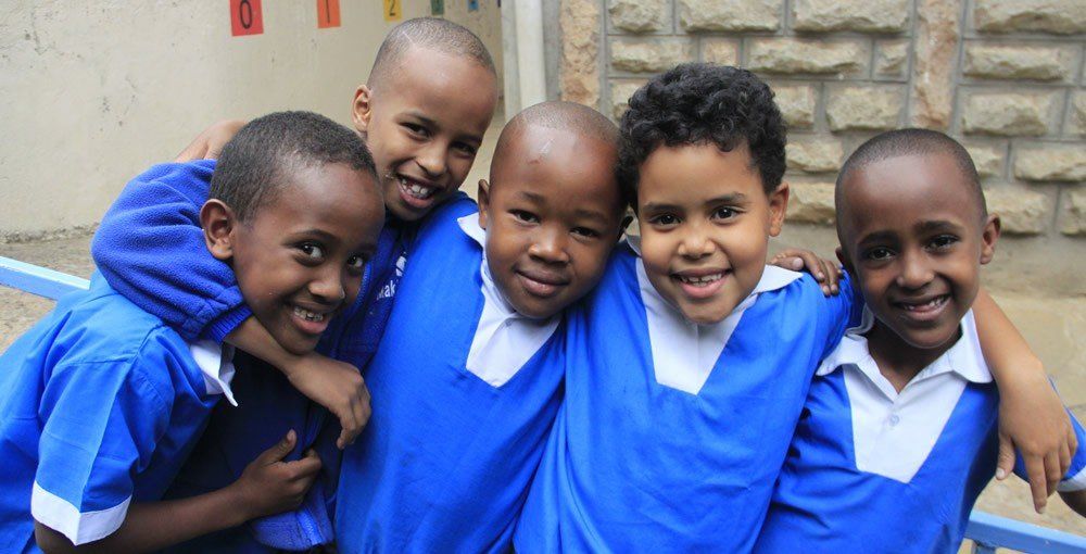 A group of children in blue uniforms are posing for a picture.