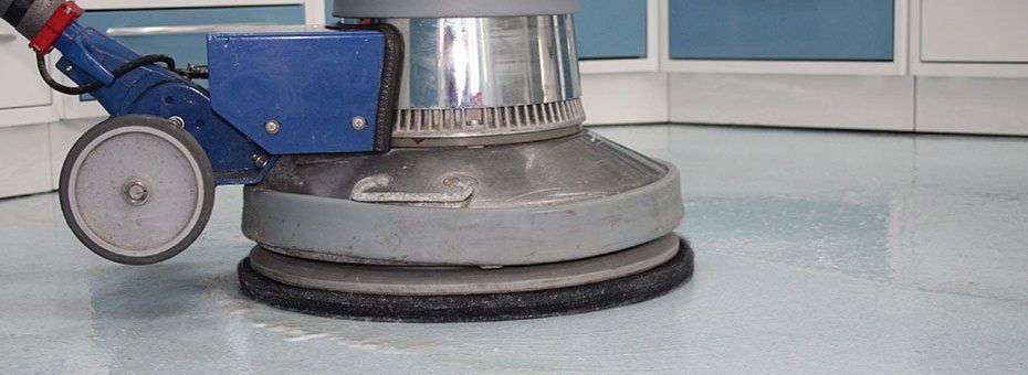 Bodenpoliermaschine poliert einen glänzenden, blaugrauen Boden.