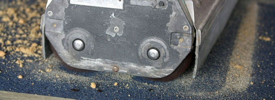 Nahaufnahme eines Maschinenteils mit zwei Metallnieten und kleinen Holzstücken.