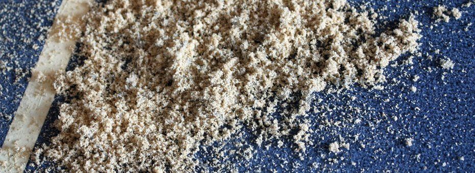 Cremefarbenes Pulver auf blauer Oberfläche mit weißem Streifen.