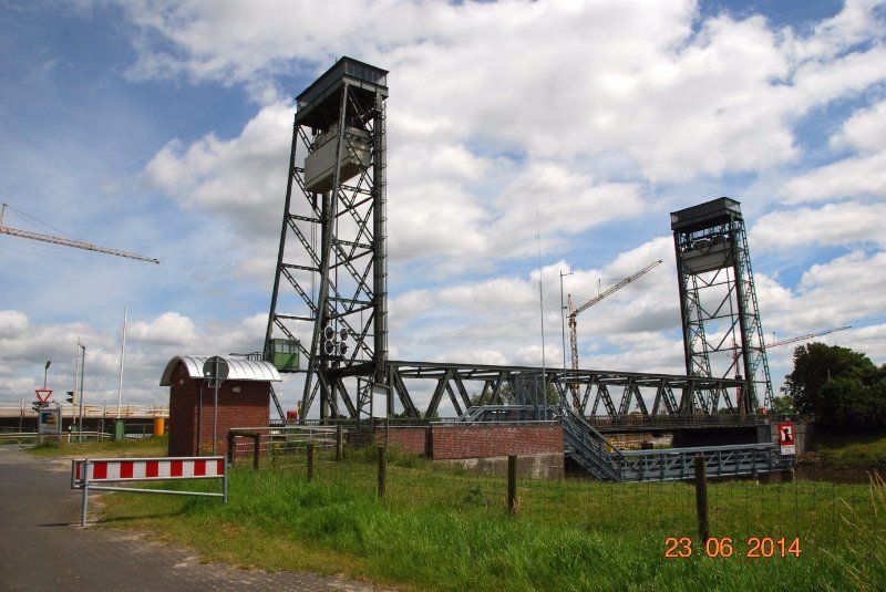 Eine Zugbrücke mit zwei Türmen vor bewölktem Himmel. Die Brücke führt über einen Wasserweg.