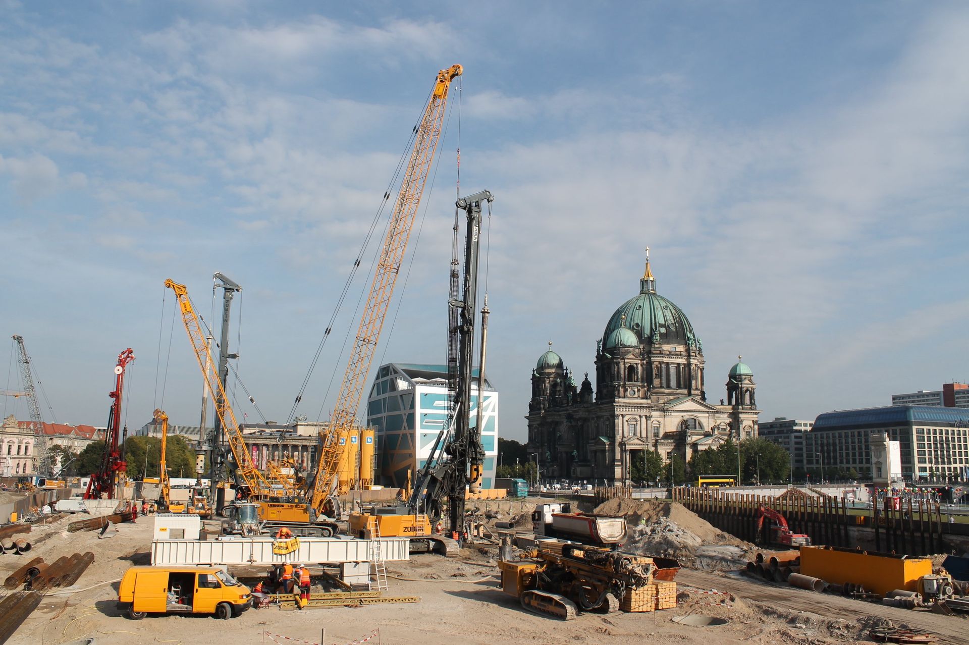 Baustelle mit Kränen in der Nähe des Berliner Doms unter blauem Himmel.