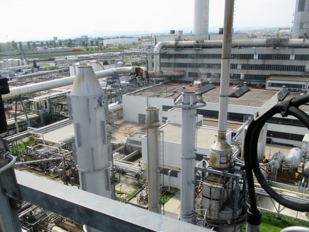 Industrieanlage mit Türmen, Rohrleitungen und Gebäuden. Aussichtspunkt an einem sonnigen Tag.