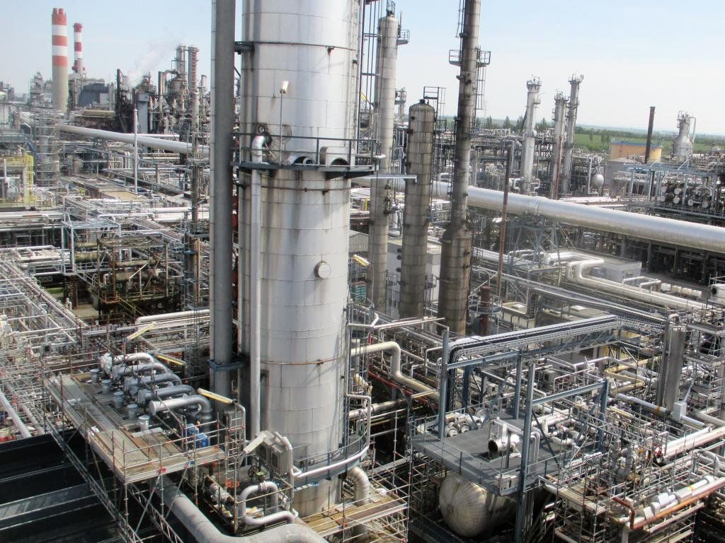 Industrieanlage mit zahlreichen Rohren, Tanks und Türmen. Bewölkter Himmel.