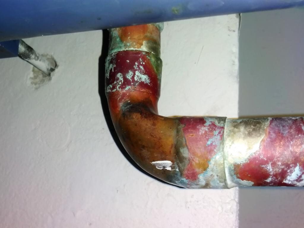 Kupferrohr mit Korrosion und Wasserflecken.