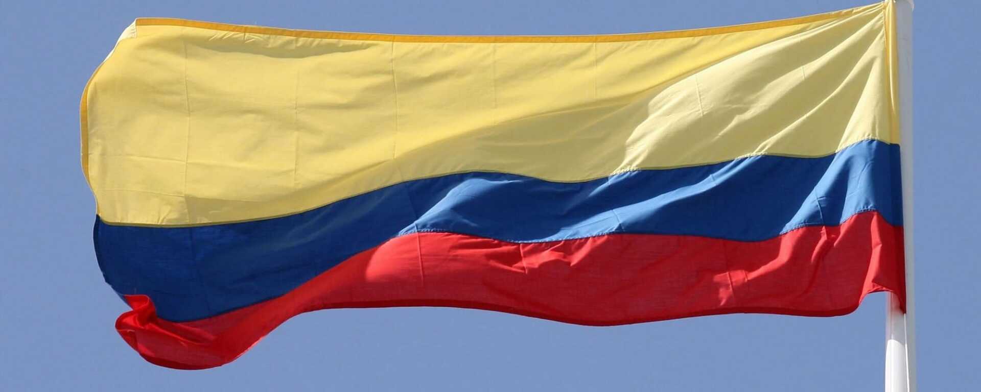 Bandera colombiana ondeando contra un cielo azul