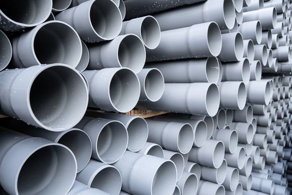 Gray PVC tubes plastic pipes stacked in rows