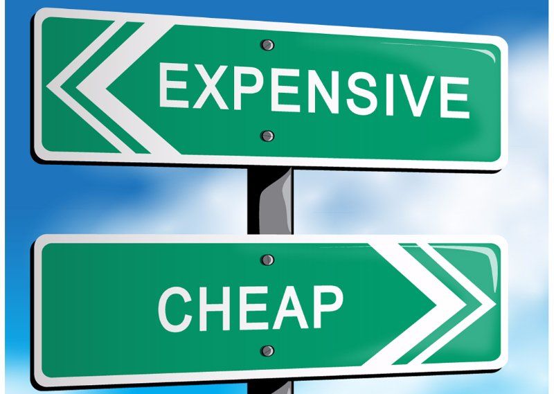 Two green street signs that say expensive and cheap