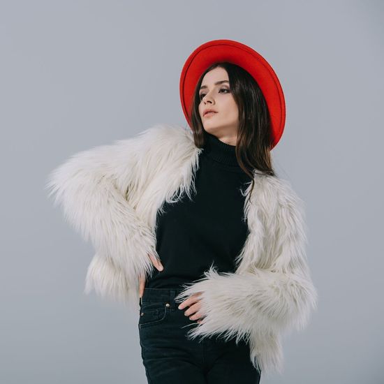 Woman Wearing Coat and Red Hat — Bayonne, NJ — Famous Furs Ltd. Woman Wearing Coat and Red Hat — Bayonne, NJ — Famous Furs Ltd.