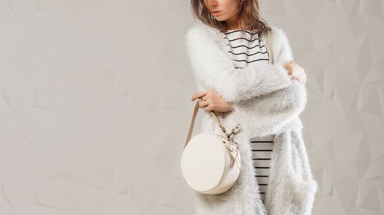 Woman with White Fur Coat and White Bag — Bayonne, NJ — Famous Furs Ltd. Woman with White Fur Coat and White Bag — Bayonne, NJ — Famous Furs Ltd.