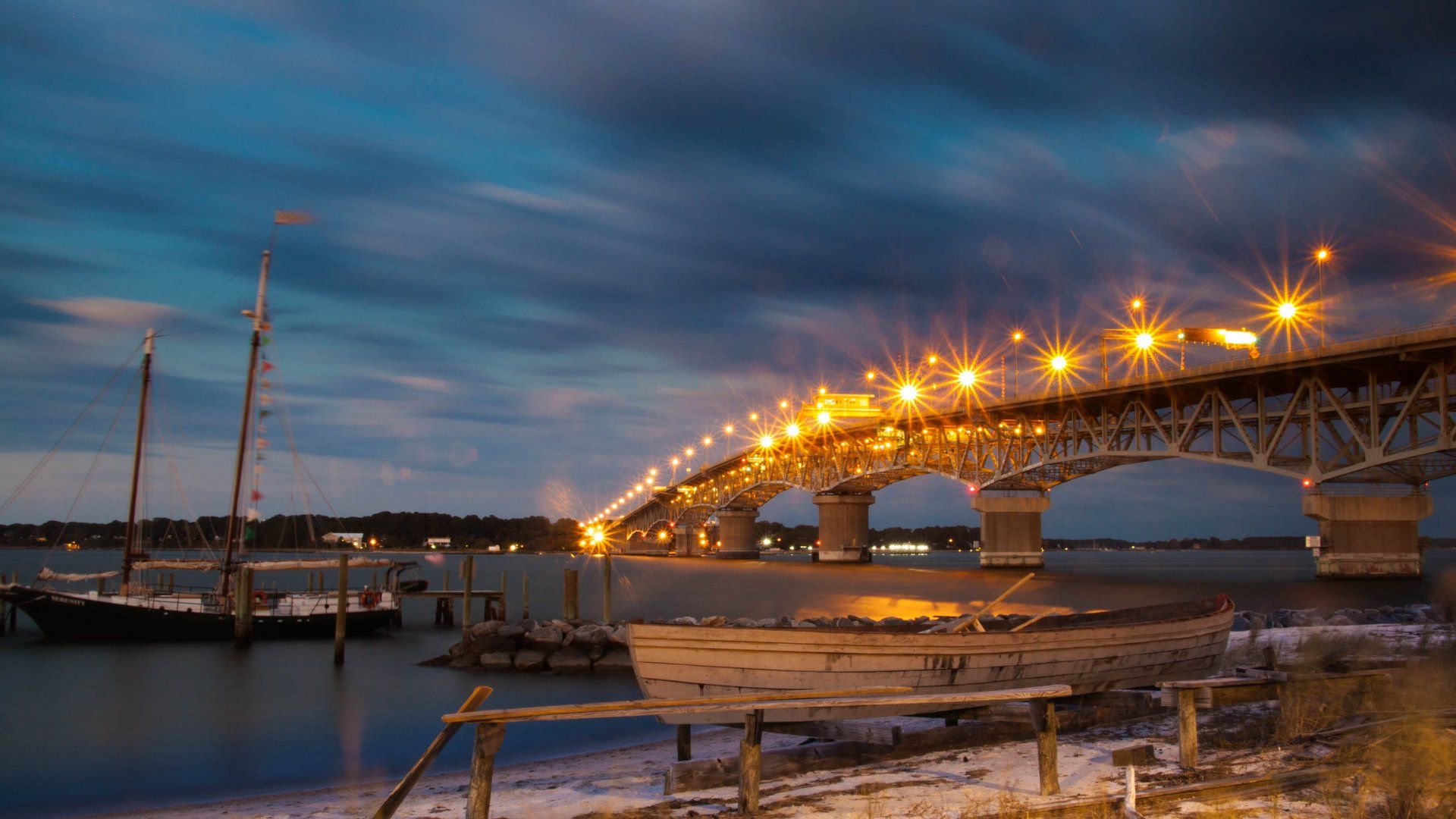 A bridge over a body of water with a boat in the foreground.