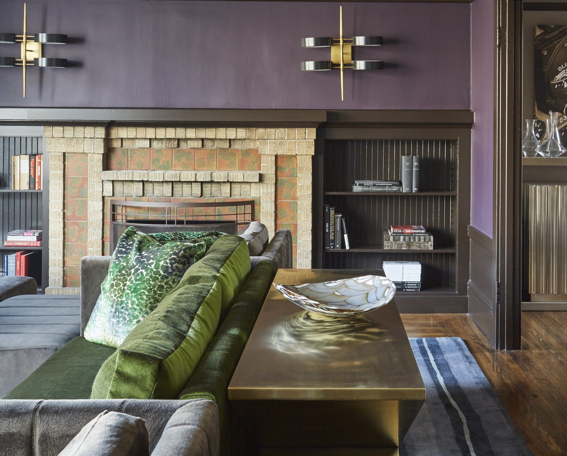 A living room with a green couch and a fireplace