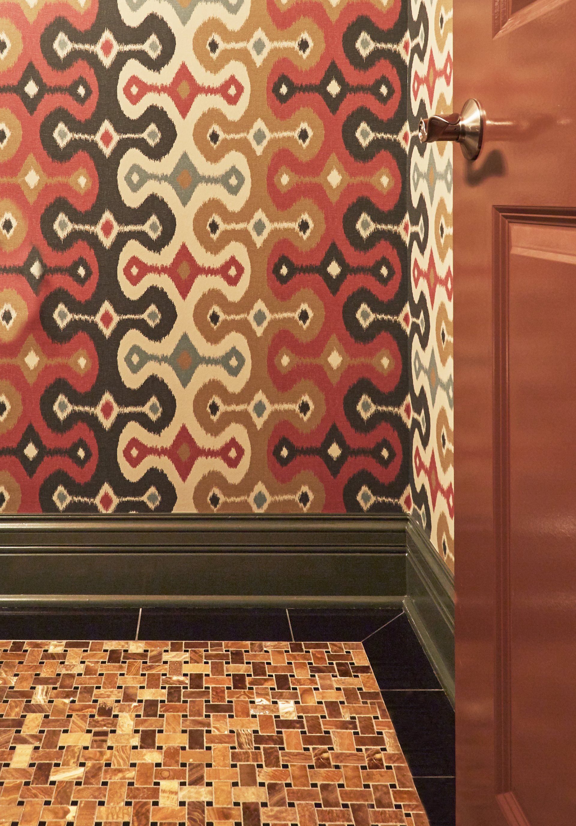 A door with a patterned wallpaper on the wall