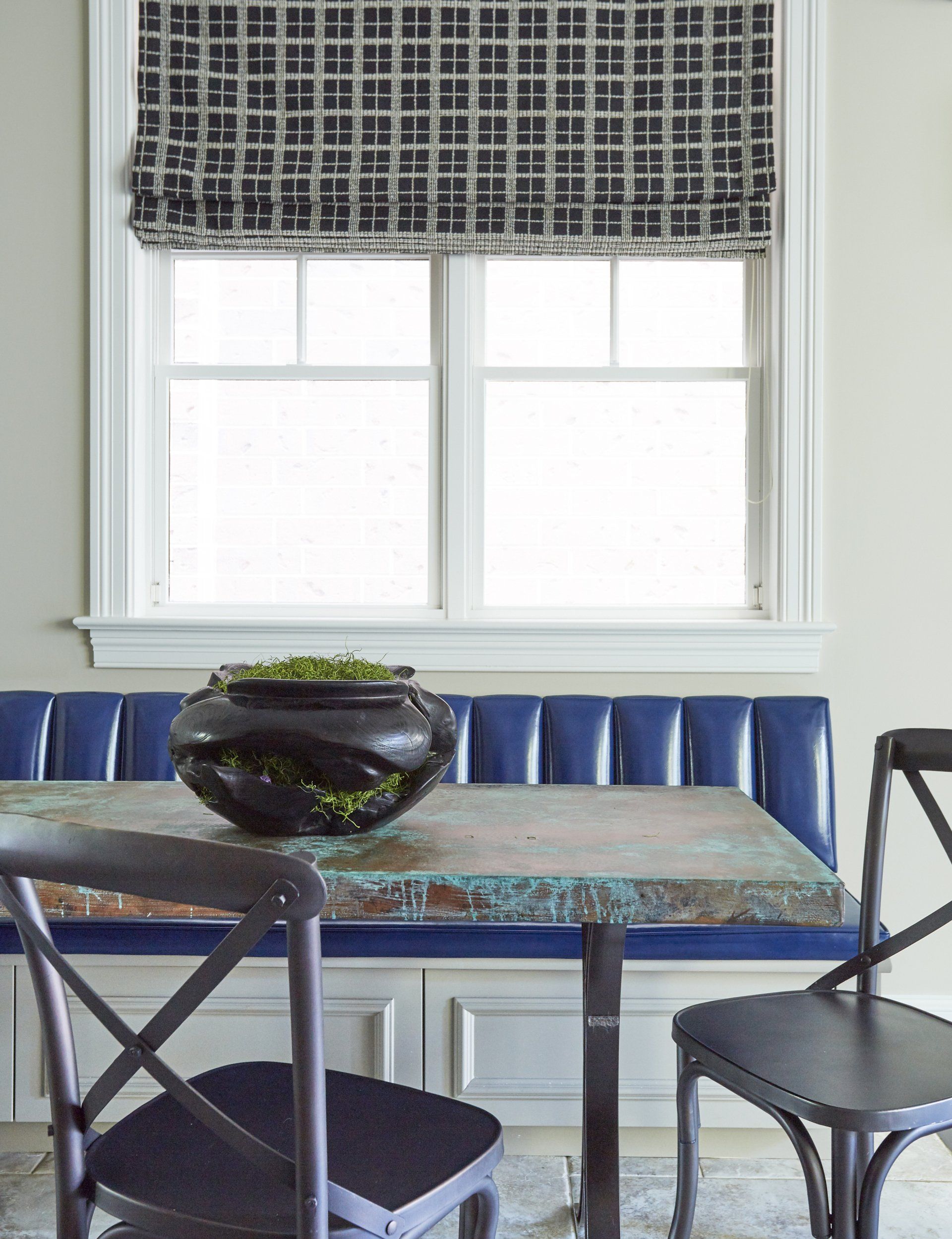 A dining room with a table and chairs and a window