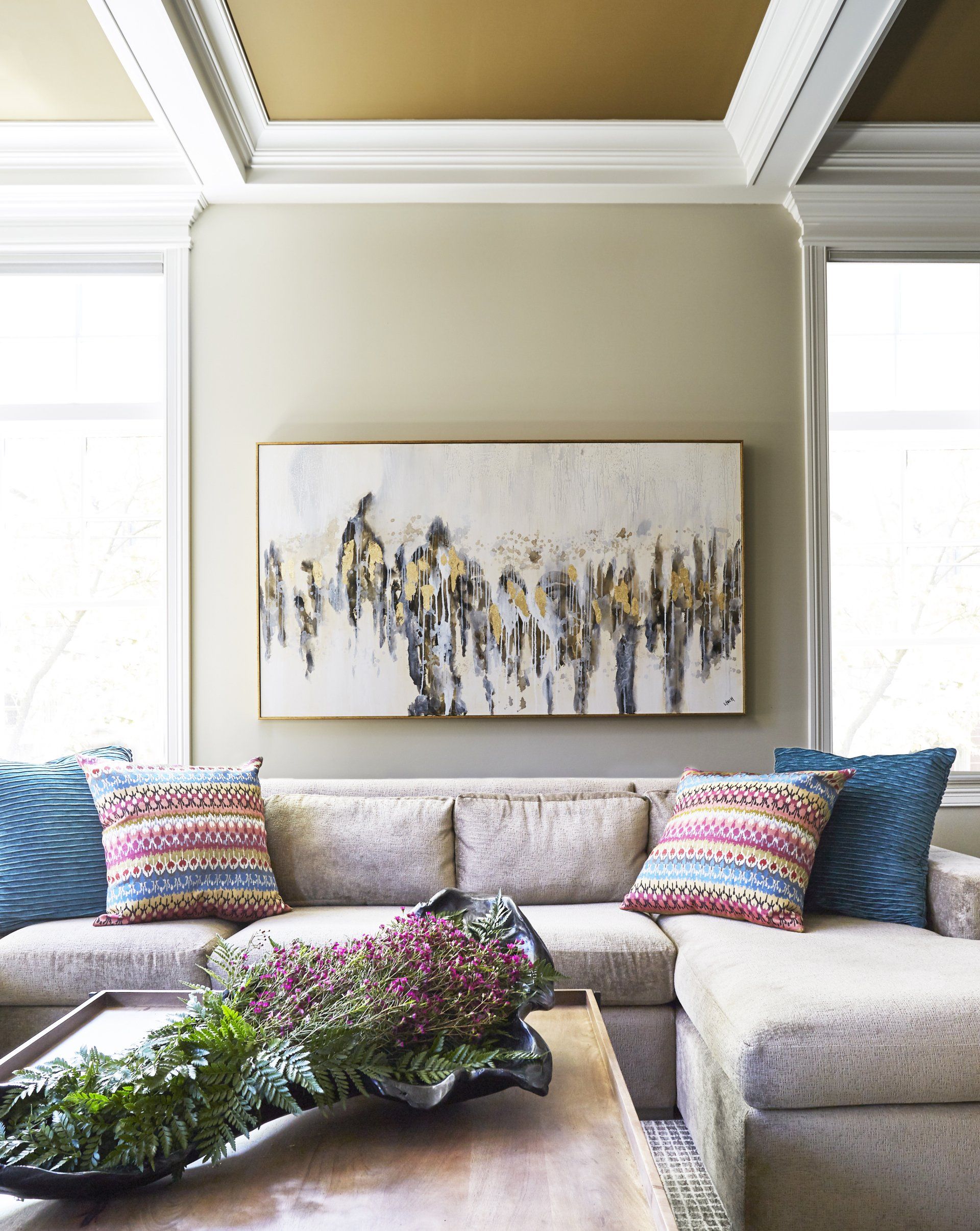 A living room with a couch and a painting on the wall